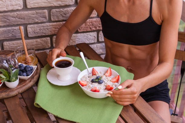 Fitness woman have a healthy breakfast. healthy homemade oatmeal with berries.